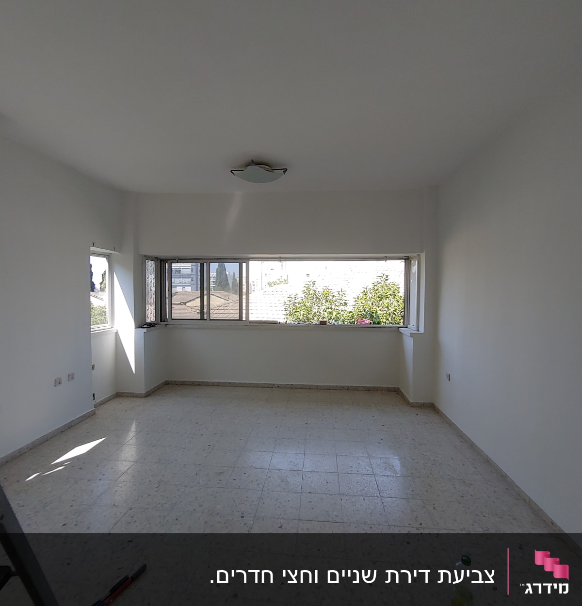 חדר ריק עם קירות צבועים בלבן וכלי עבודה על הרצפה